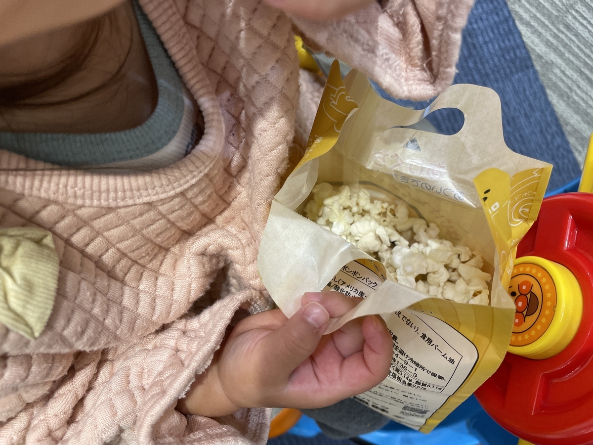 ぐでたまのホップコーンを食べる女児
