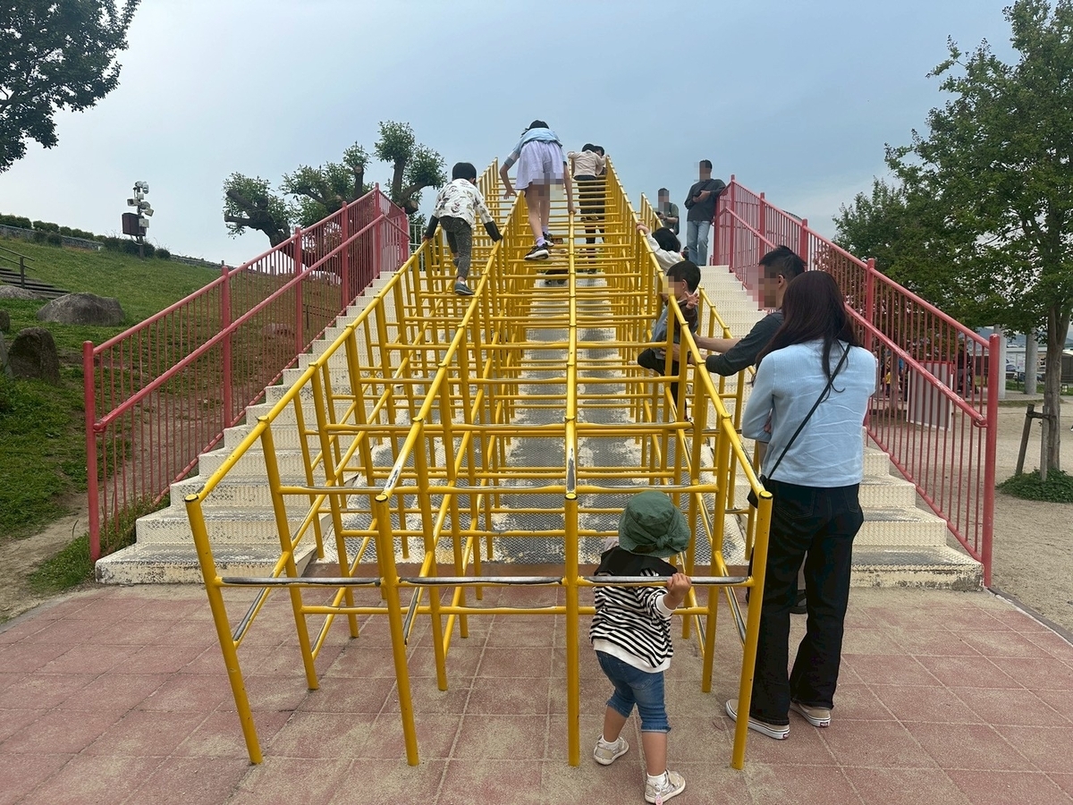 豊中市観光スポット｜飛行機の離発着を見ながら遊具で遊べる公園「伊丹スカイパーク」の遊具エリアにあるジャングルジムで遊ぶ子ども達