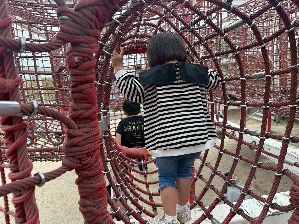 豊中市観光スポット｜飛行機の離発着を見ながら遊具で遊べる公園「伊丹スカイパーク」の遊具エリアにある立体迷路に入る子ども達
