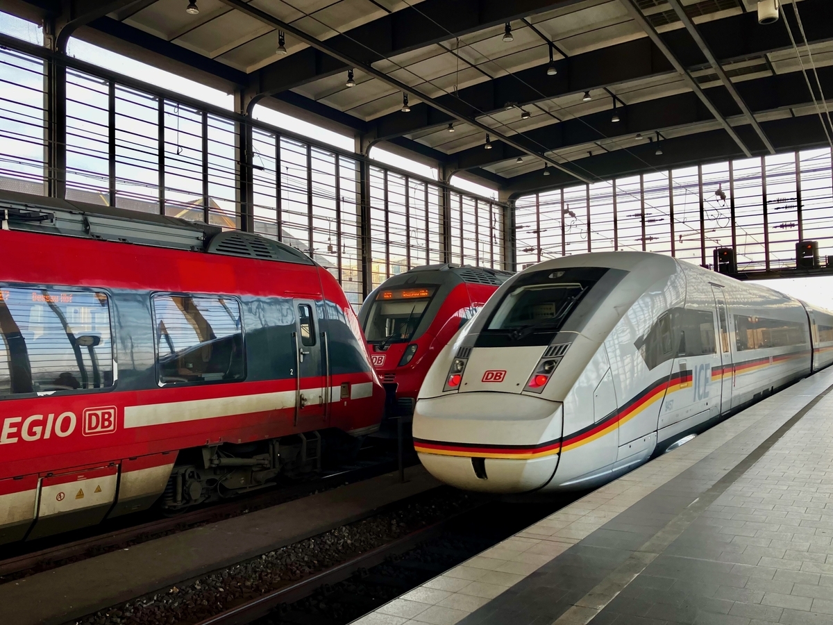 ベルリン・ツォー駅(Zoo駅)のホームに停車中のドイツ鉄道(DB)の超特急ICEと赤い車体の快速列車RE(REGIO)