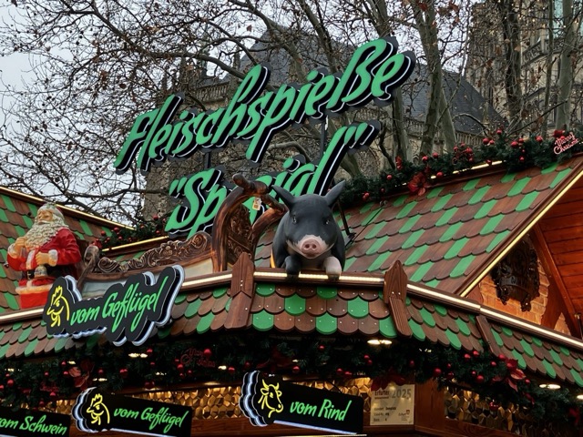 豚のオブジェと「Fleischspieße（串焼き肉）」の看板が目を引くドイツのクリスマスマーケットの肉料理屋台