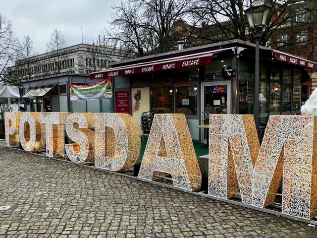 ドイツ・ポツダムのクリスマスマーケット会場に設置された「POTSDAM」の大きな文字オブジェと、背後に並ぶ飲食の屋台