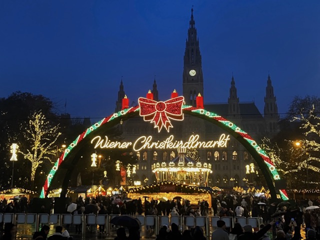 ウィーン市庁舎前のクリスマスマーケット入り口にある「Wiener Christkindlmarkt」の光り輝くアーチと夜景