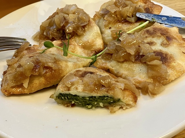 ほうれん草のフィリングが詰まった焼きピエロギの断面
