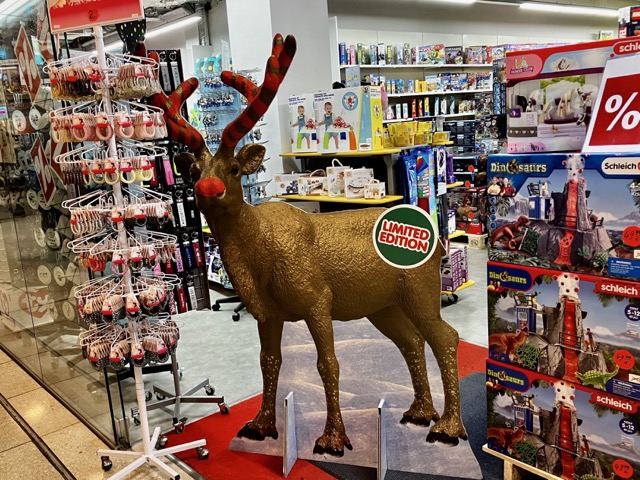 おもちゃ屋の店頭に置かれた、トナカイの等身大パネルとクリスマスギフト用の商品棚