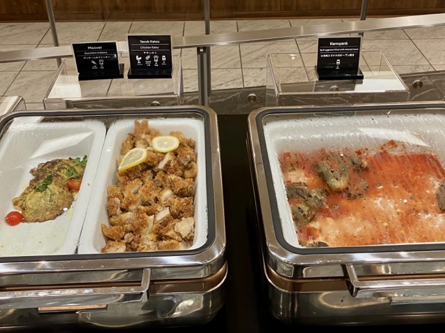 ターキッシュラウンジで提供される温かい料理（チキンカツやナス料理）