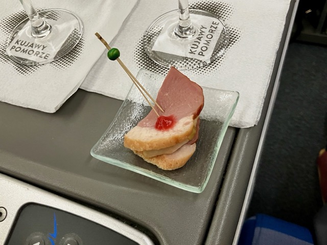 機内食のアペタイザー。一口サイズの鴨肉、赤いソース添え
