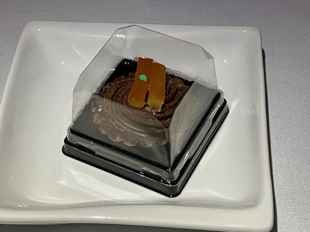 デザートのチョコレートケーキ。オレンジピールが添えられ、機内で提供された状態のパッケージ