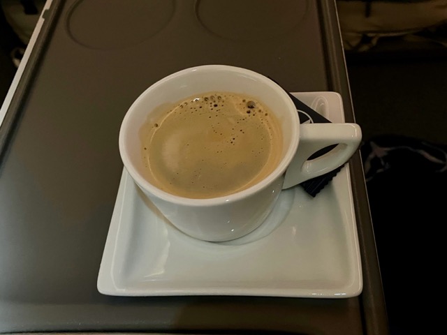 食後のコーヒー。LOTポーランド航空のロゴが入ったカップと、機内のテーブルトレイ