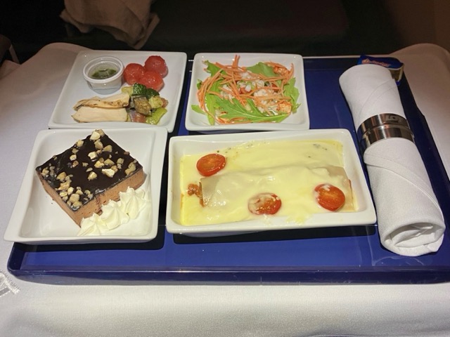 2度目の食事(軽食)のトレイ全景。カネロニ、サラダ、前菜、ナッツの乗ったチョコケーキ