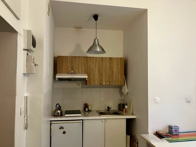 部屋に備え付けられたコンパクトなキッチン。コンロ、シンク、冷蔵庫が機能的に配置されている