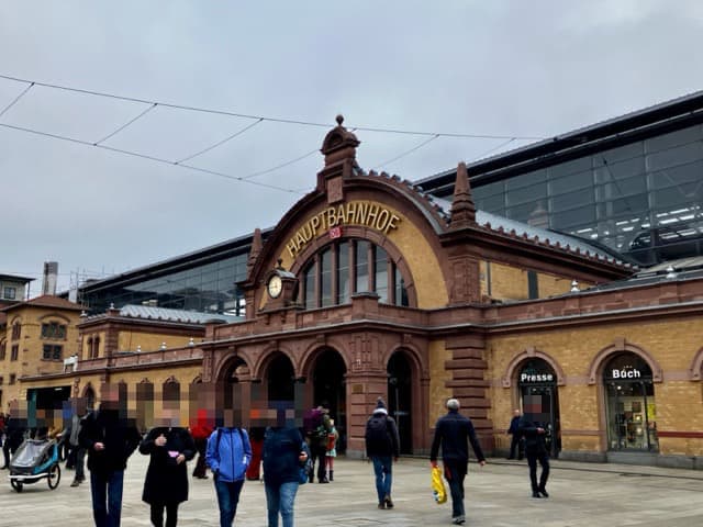 冬のどんよりした空とエルフルト中央駅の外観。レンガ造りの歴史的なファサードに「HAUPTBAHNHOF」の文字が見える