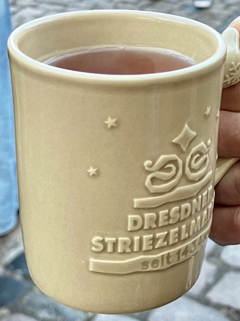 「DRESDNER STRIEZELMARKT」のロゴが刻印された、歴史を感じさせるベージュの陶器マグカップ