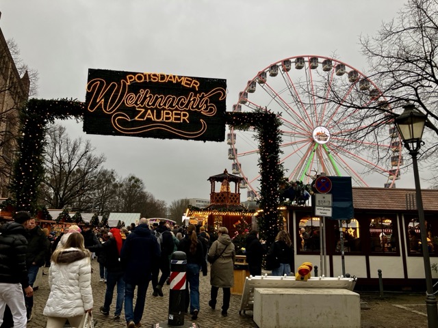 「Potsdamer Weihnachts Zauber」と光るネオン看板。奥にはライトアップされた観覧車
