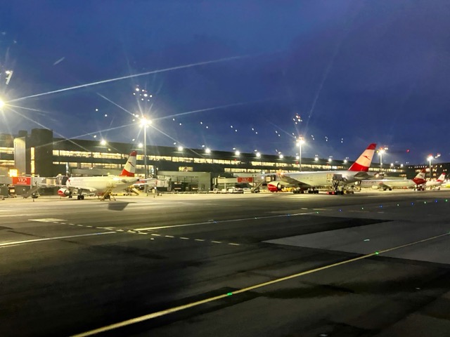 夕刻のウィーン国際空港（VIE）に到着。駐機場に並ぶオーストリア航空の機体とライトアップされたターミナル