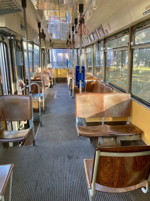 旧型トラムの車内通路。吊り革や検札機が並ぶノスタルジックな雰囲気