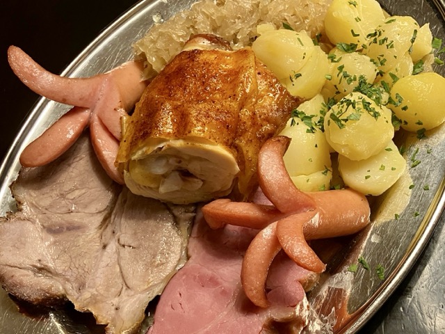 ホイリゲのメイン：スモークポーク、ローストポーク、チキン、ソーセージ、ザワークラウト、ポテトの盛り合わせ
