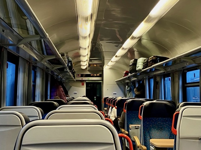 レーゲンスブルク行きの列車の清潔な車内座席と荷物棚に置かれたスーツケース
