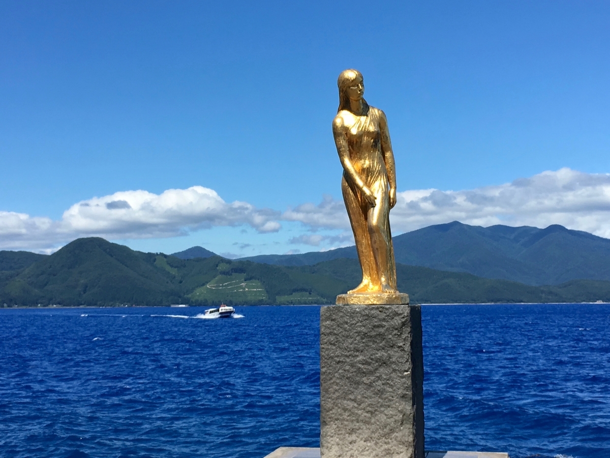 田沢湖ブルーにじっとたたずむたつこ像