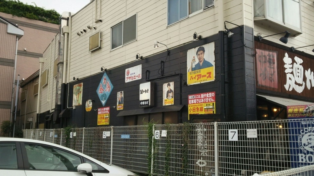 昔懐かしい古びたホーロー看板が何枚も貼られた、麺や食道の外壁