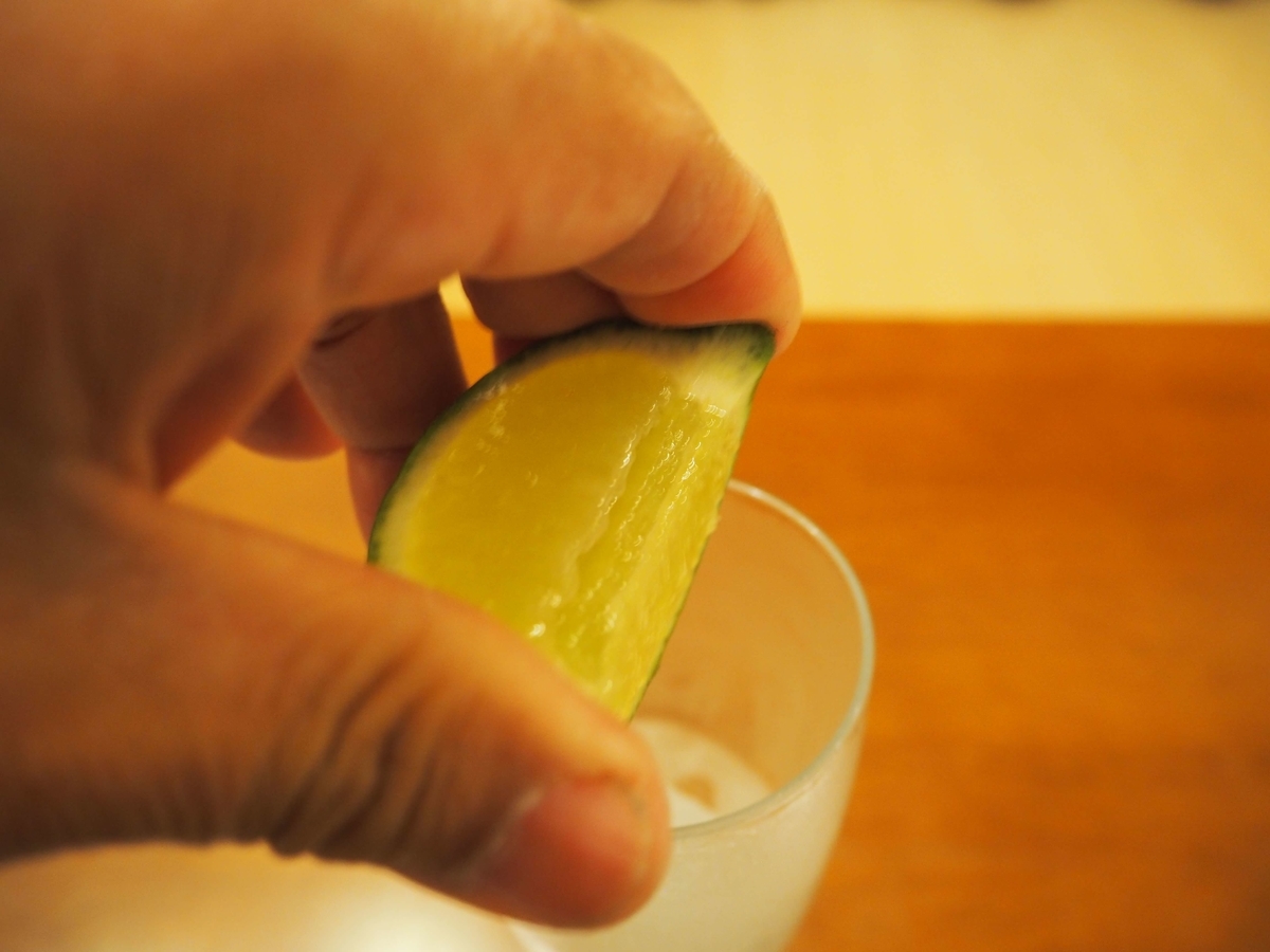 グラスに絞り入れられるライム