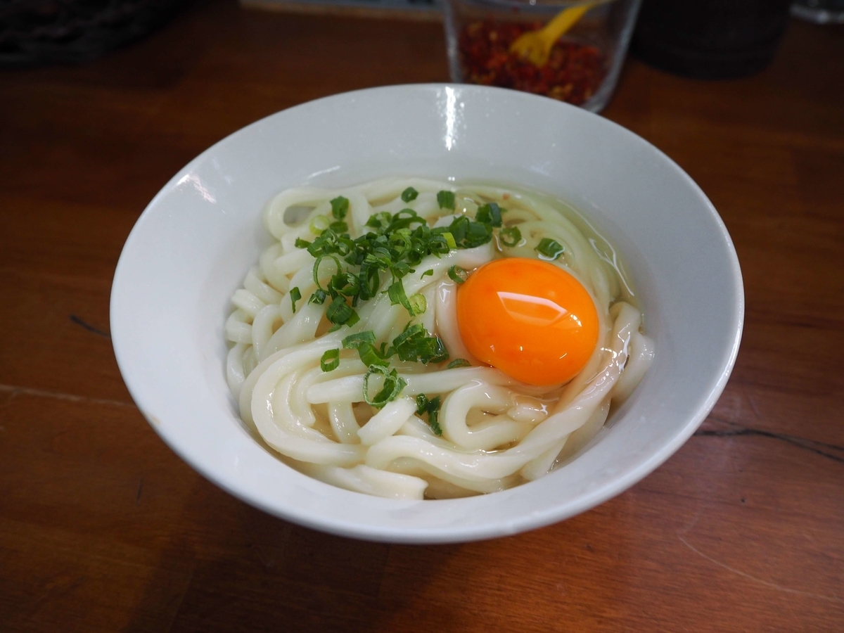 温かいうどんと生卵とねぎ
