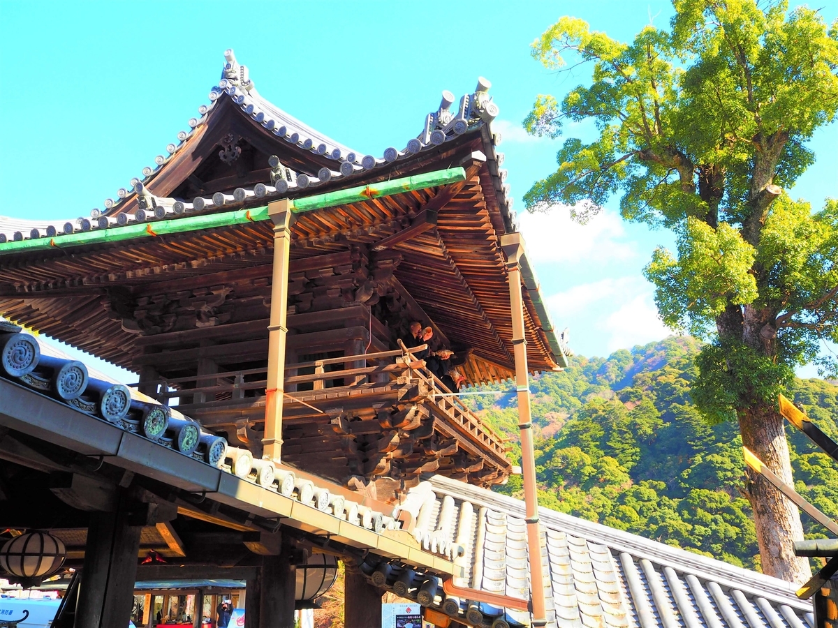 鐘楼でほら貝を吹く僧