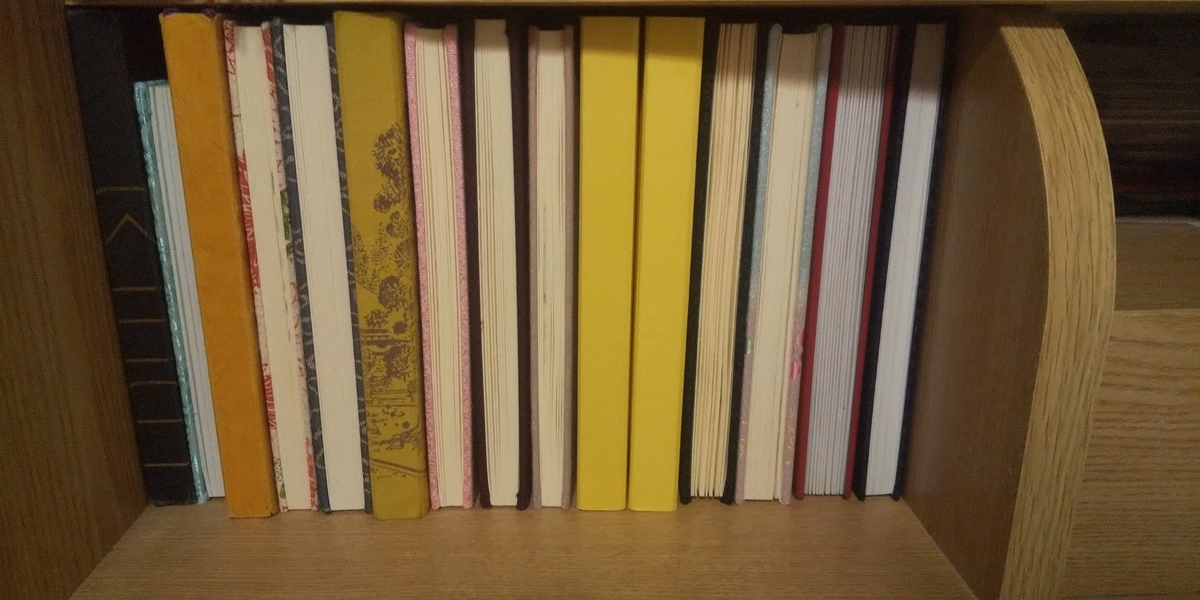 御朱印帳でいっぱになったベッドの枕元の棚