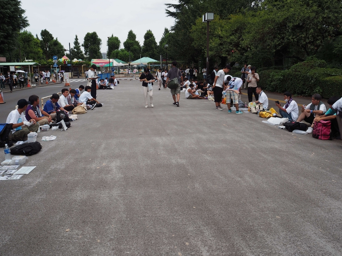 道端で生写真の交換をしている人々