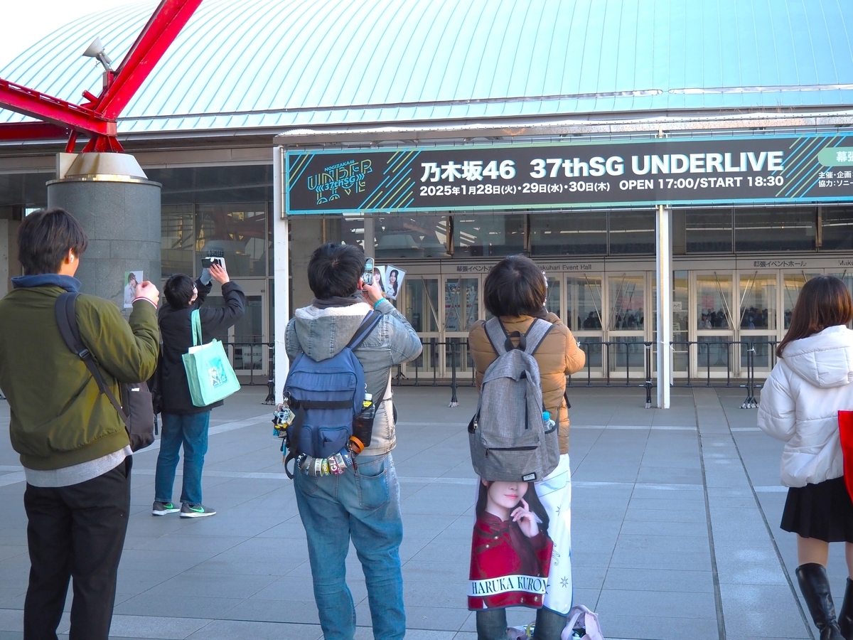 看板を撮影する人々