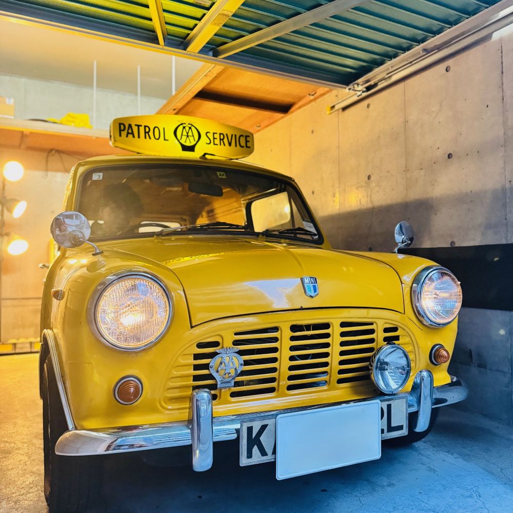 Classic Mini AA van parked in private garage illuminated at night after delivery