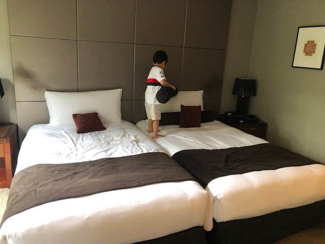 エクシブ箱根離宮のスタンダードグレードの部屋のベッドに乗っている子ども