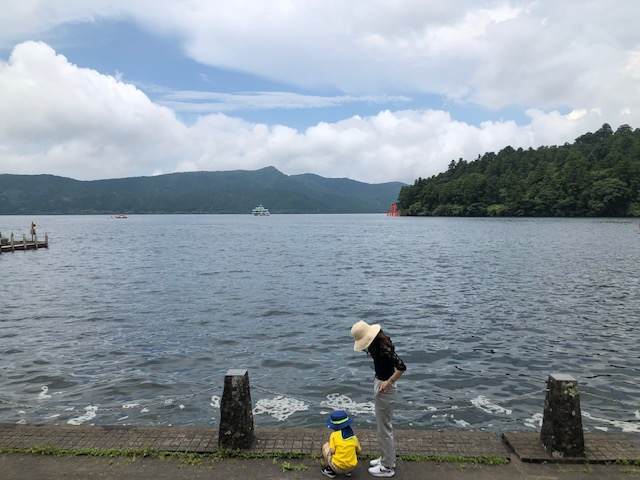 芦ノ湖のほとりに立つ子どもと女性