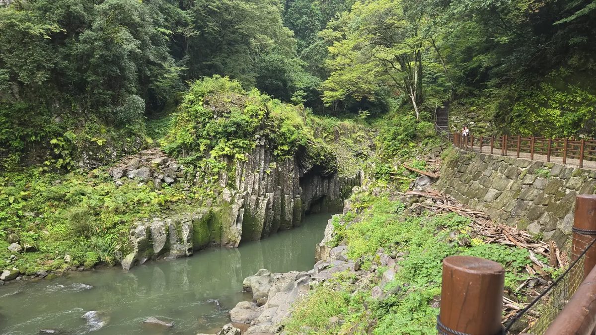 高千穂峡の遊歩道から眺める渓谷の景色。柱状節理の岩壁と緑の深い自然が広がる静かな散策路。