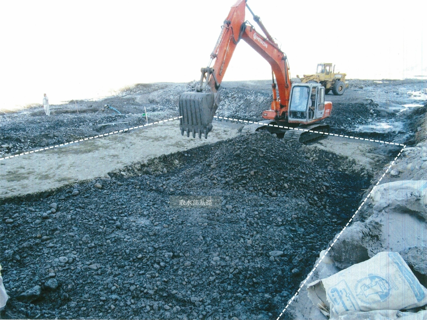 取水門基礎工事風景。掘削機でセメントと玉石を混ぜ、厚さ50cmの強靭な基礎とする(2021年1月3日)
