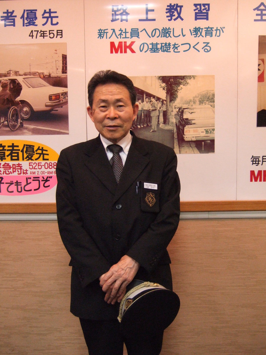 MKの歴史を説明するパネルの前で MK新聞2007年7月1日号より