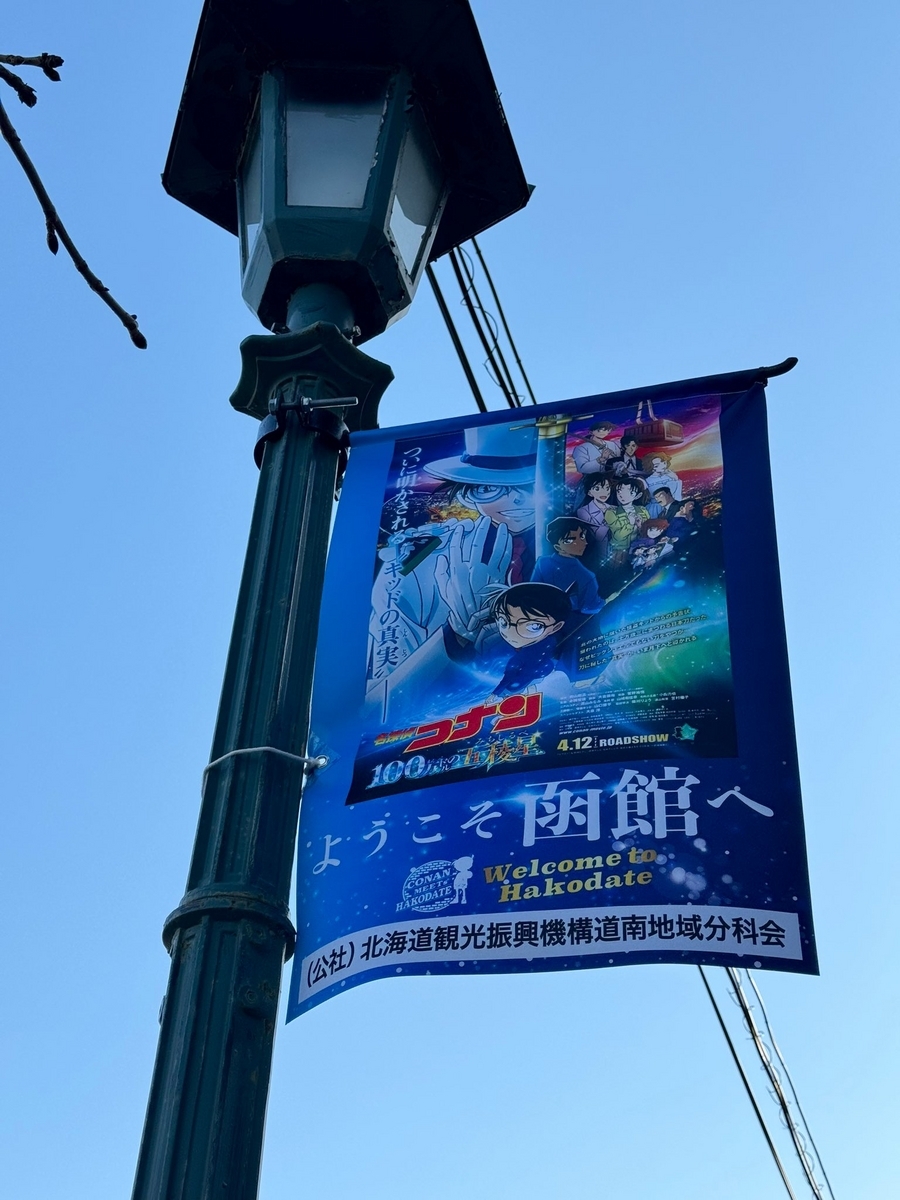 ベイエリア 赤レンガ倉庫近くの電灯に掲示されているフラッグ。春公開の名探偵コナン 100万ドルの五稜星（みちしるべ）のポスターと共に、「ようこそ函館へ」の文字。