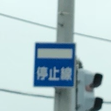 電柱に取り付けられた、停止線の青看板。