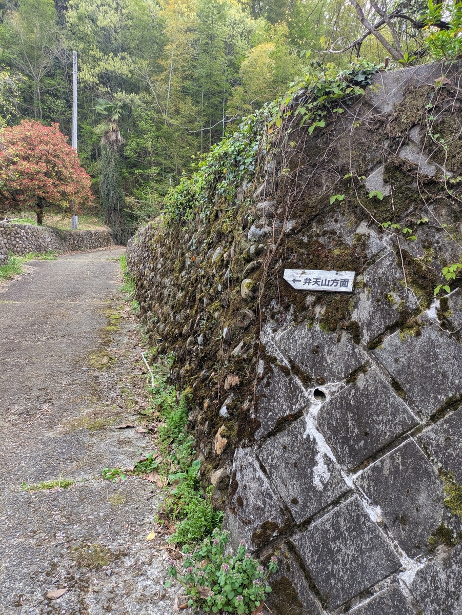 弁天山方面の標識と苔の生えた石垣