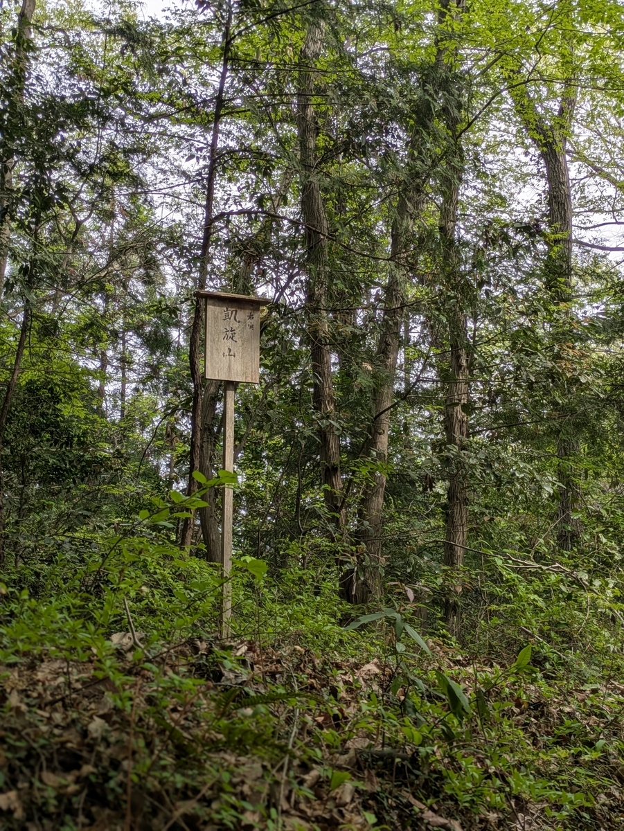 木々の間に立つ凱旋山の案内板