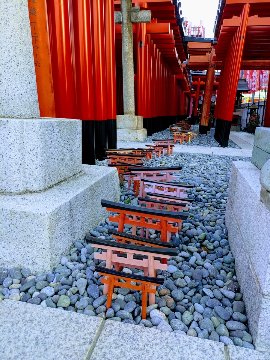 千本鳥居の間、玉砂利の上のミニ千本鳥居