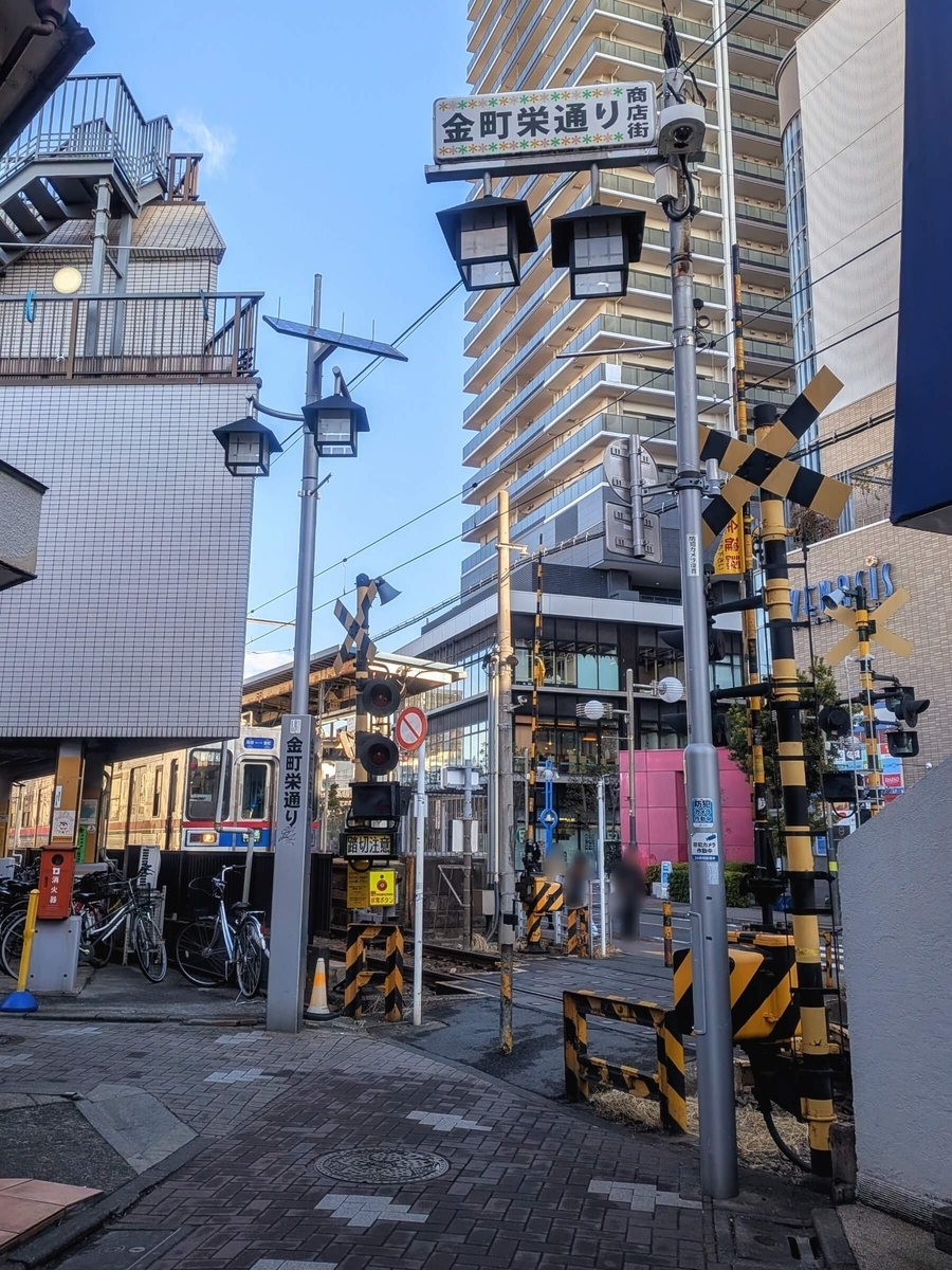 金町栄通り商店街から見る柴又第6号踏切とプラウドタワー金町