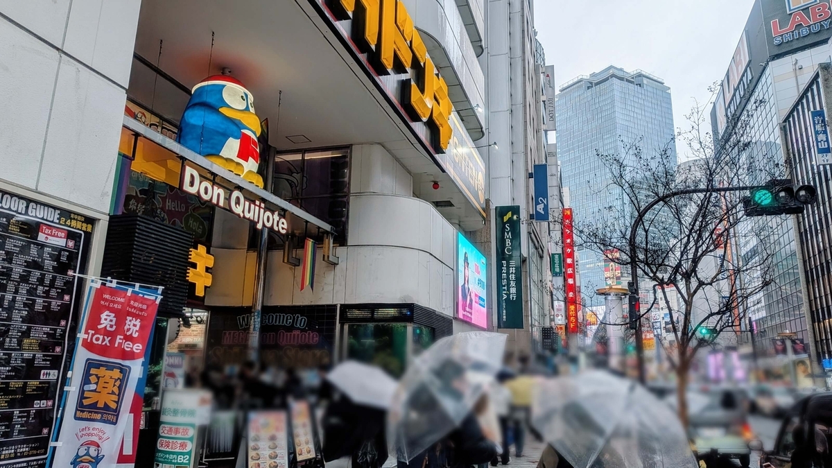傘でいっぱいの文化村通りとMEGAドン・キホーテ 渋谷本店