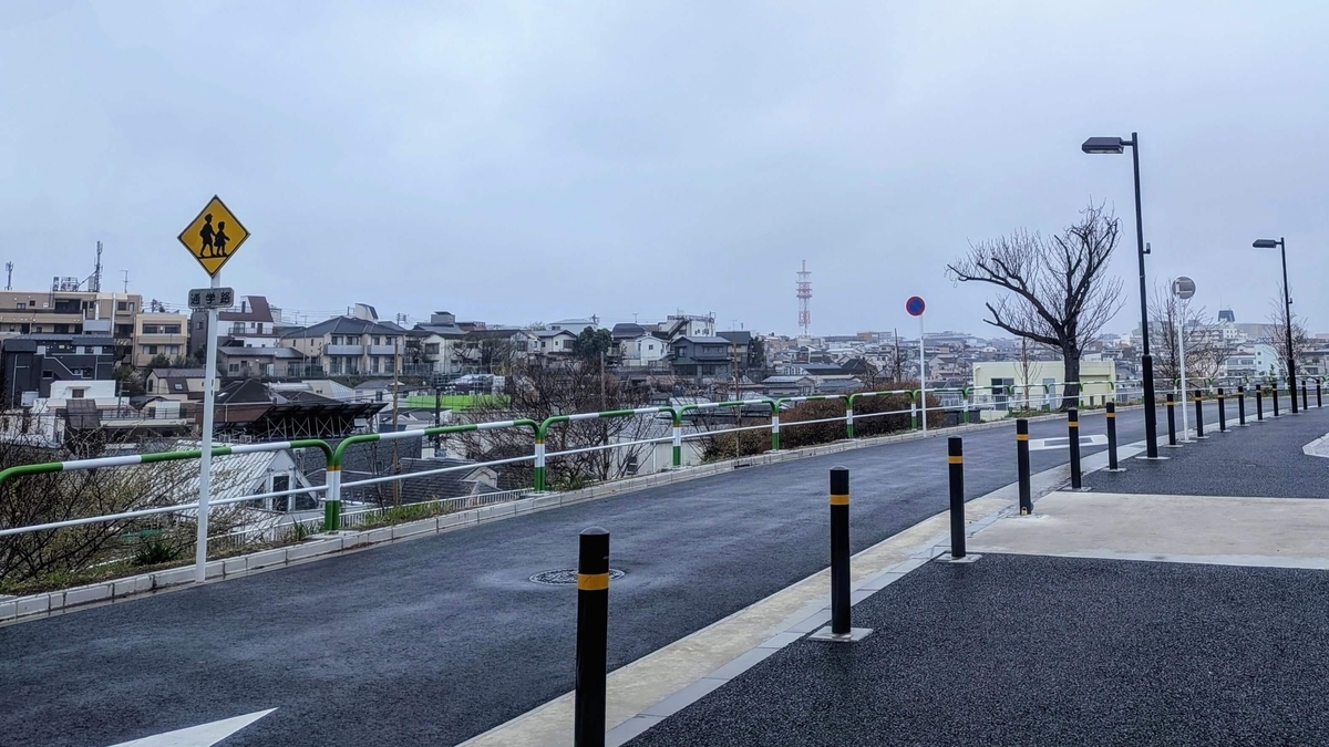 ヌーヴェル赤羽台14号棟前から見る曇り空と崖の向こうに広がる赤羽西の住宅地