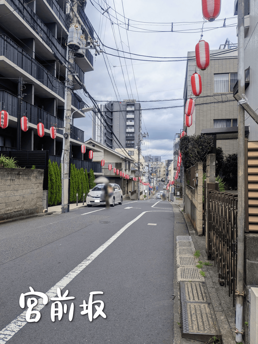 マンション、住宅の間を下る宮前坂 道の両側に紅白の提灯