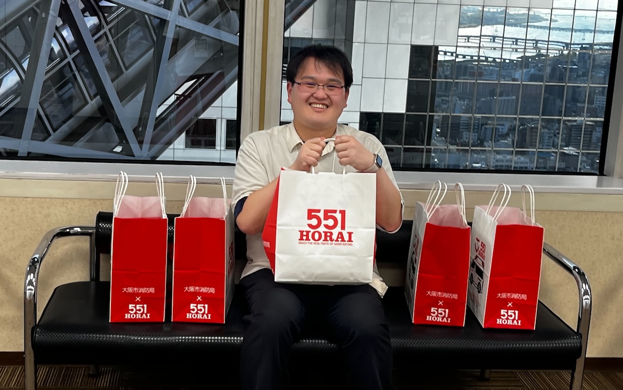 ハッカソン参加者に配った551に囲まれている山岸