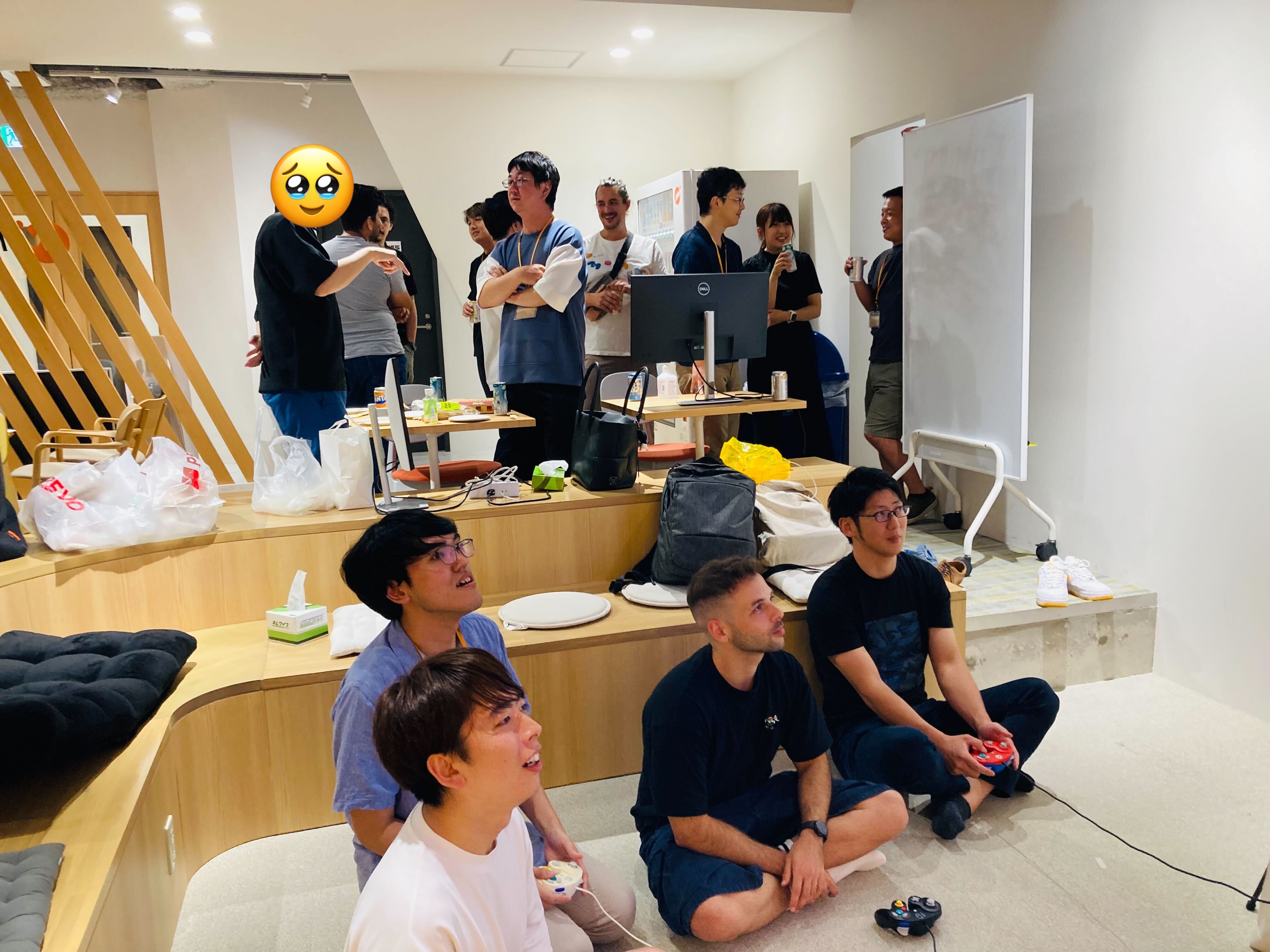 懇親会で各自ドリンクを片手に交流している様子。普段は交流のないメンバー同士でゲームしている姿も。