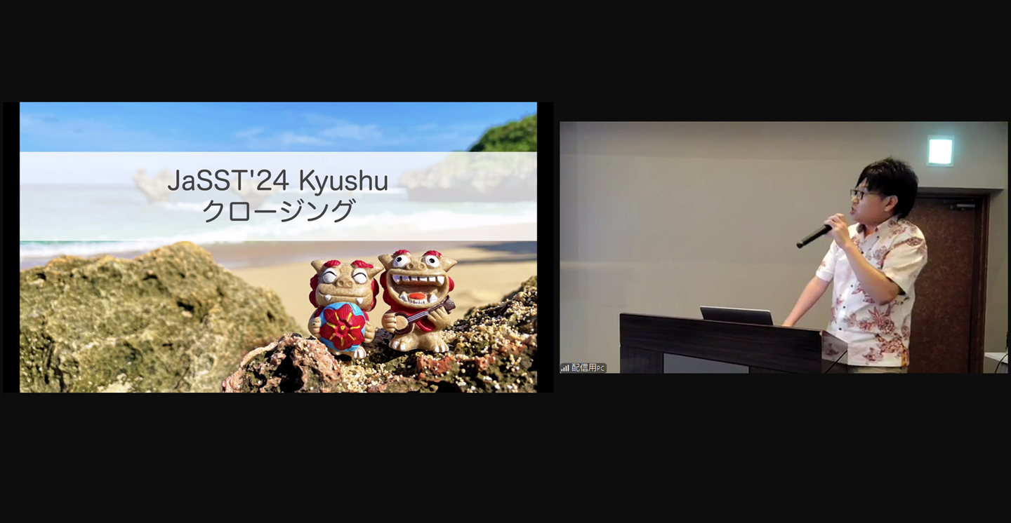 クロージングでJaSST'24 Kyushuの参加者に謝辞を述べるtosite。白地に赤の模様が入ったかりゆしウェアを着て、スライドには沖縄の海をバックに微笑むシーサーが「JaSST'24 Kyushu クロージング」という文字とともに写っている。