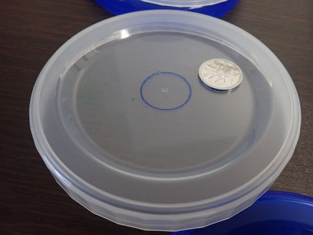 容器に孔をあける場所の印を1円玉でつける