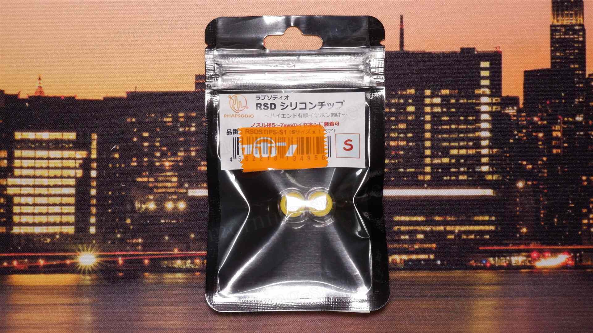 パッケージに入ったシリコンチップが写っている。背景には夜景の都市が見える。パッケージの表面には「RSD シリコンチップ」と書かれており、サンプルサイズや商品コードが記載されている。